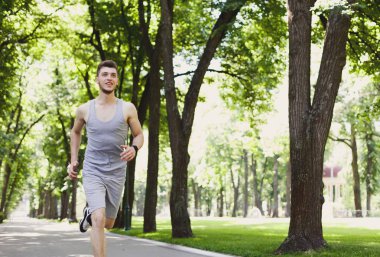 Yeşil park, kopya alanı koşan genç adam
