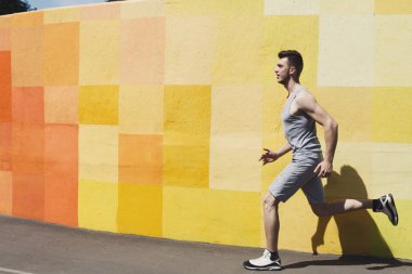 Parlak duvara koşan adam yan görünüm