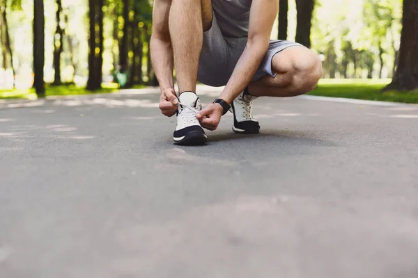 Hombre irreconocible atando cordones antes de correr —  Fotos de Stock