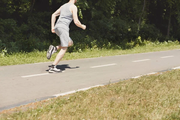 Jovem jogging homem na esteira no parque, espaço cópia — Fotografia de Stock