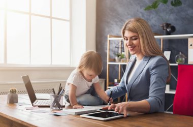 Genç anne holding bebek çalışırken