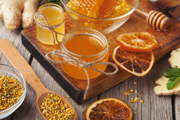 Various types of honey on wooden platter, closeup