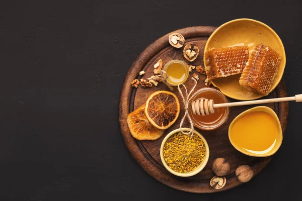 Various types of honey on wooden platter, closeup — Stock Photo, Image