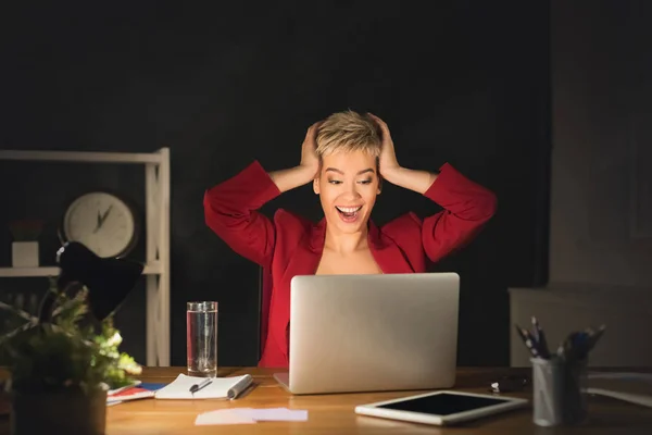 Donna sorpresa che lavora sul computer portatile a tarda notte in ufficio — Foto Stock