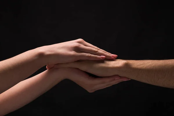 Händerna på man och kvinna i kärlek, isolerade på svart — Stockfoto