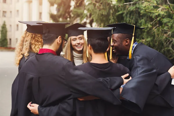 Absolventen beim gemeinsamen Umarmen am Abschlusstag — Stockfoto
