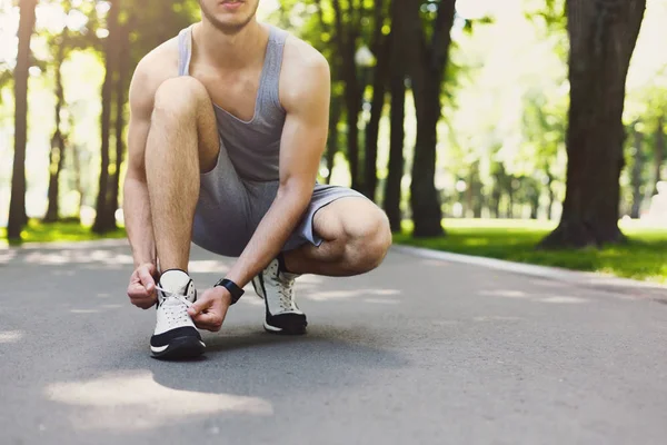 Homem irreconhecível amarrando atacadores antes de correr — Fotografia de Stock