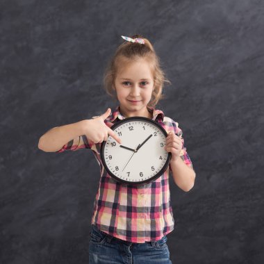Gülümseyen kız büyük saat, holding üzerine işaret