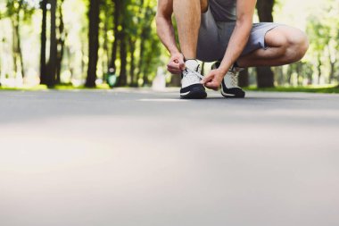 Tanınmayan adam bağlama ayakkabı bağcığı spor ayakkabı koşu Parkı, portre, kopya alanı, için hazırlanıyor çalıştırmadan önce üzerinde kırpma