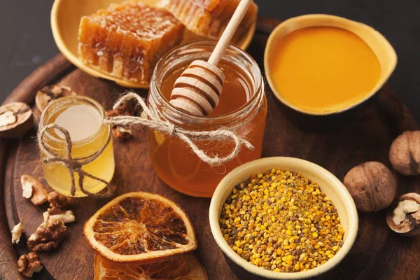 Various types of honey on wooden platter, closeup — Stock Photo, Image