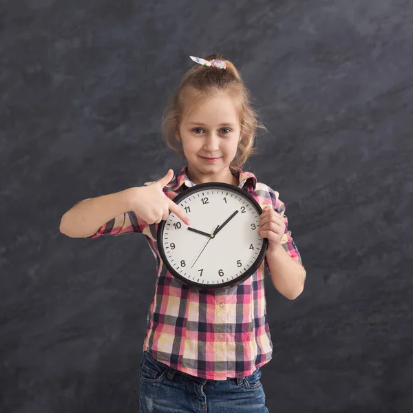 Gülümseyen kız büyük saat, holding üzerine işaret