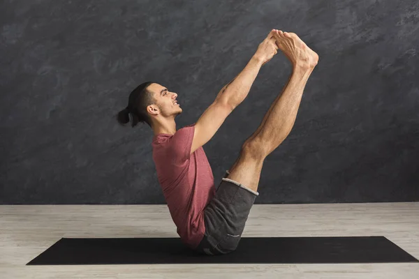 Jonge man het beoefenen van yoga met gymnastische mat — Stockfoto