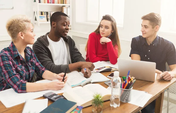 Groupe d'étudiants divers étudiant à la table en bois — Photo