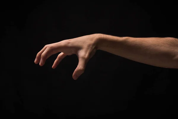 Manlig hand plocka upp något, utklipp på svart — Stockfoto
