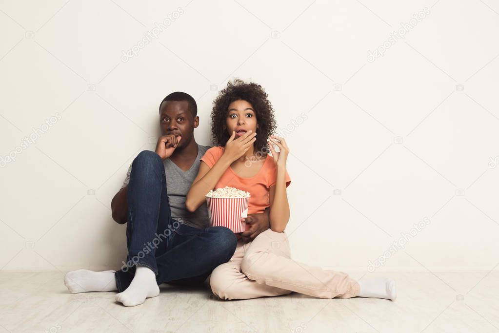 Black couple wathing scary movie at home