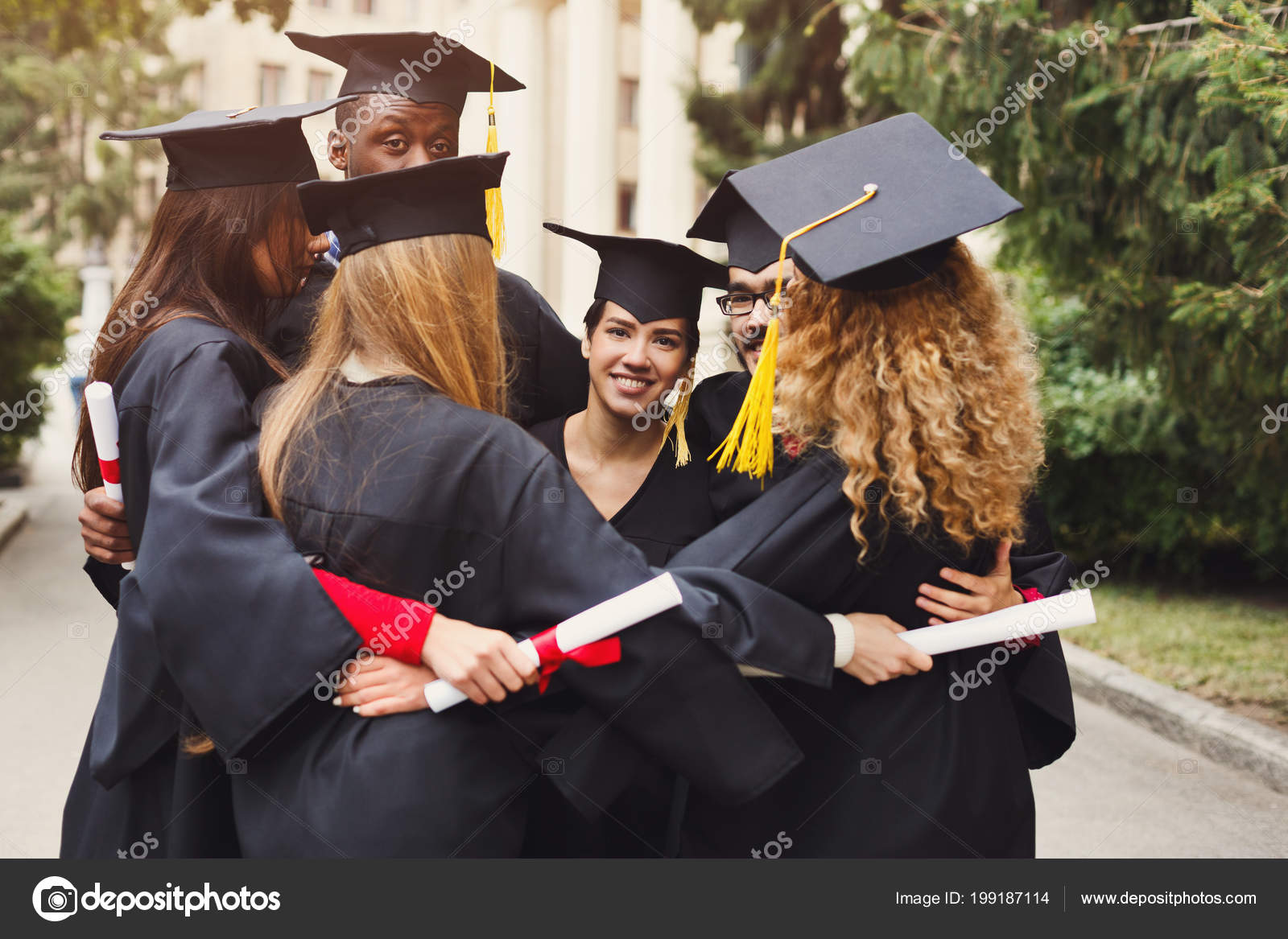 Graduates having group hug on graduation day — Stock Photo
