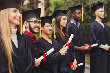 Onların diploma mezuniyet günü, mutlu insanlar kutluyor eğitim derecesi, kopya alanı üzerinde tutan çok ırklı öğrenci grubu