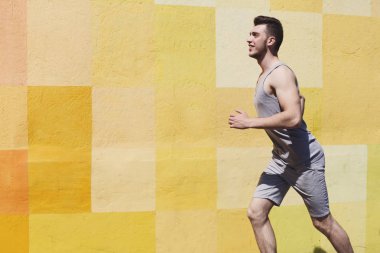 Parlak duvara koşan adam yan görünüm