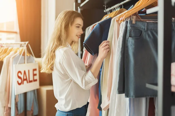 Sonriente chica bying ropa en sala de exposición — Foto de Stock