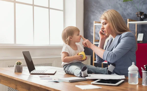Jonge moeder praten over telefoon en tijd doorbrengen met baby — Stockfoto