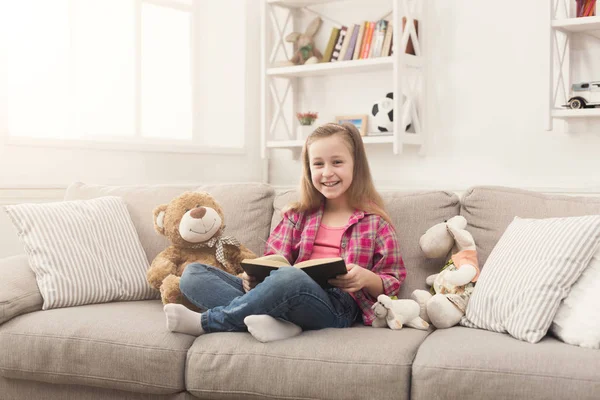 Happy little child reading book for her teddy bear — Stock Photo, Image