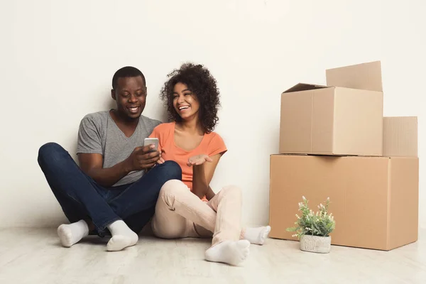 Black couple sitting on floor at new apartment