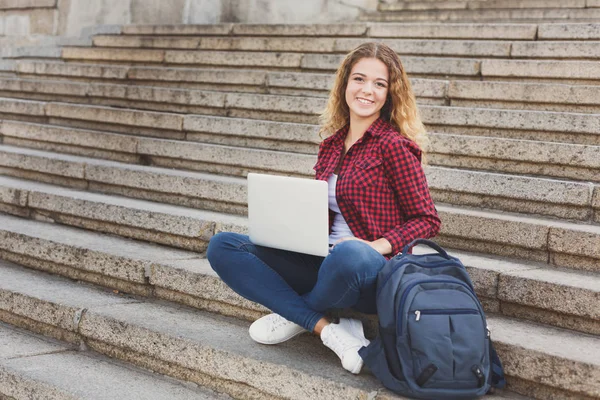Merdivenlerde oturan ve dışarı laptop ile çalışan kız öğrenci — Stok fotoğraf