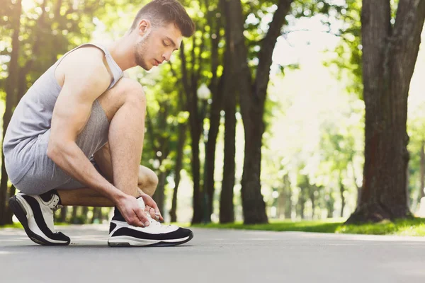 Homem muscular amarrando atacadores antes de correr — Fotografia de Stock