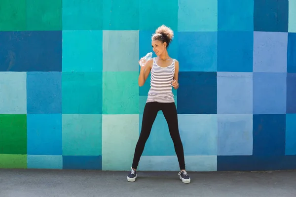 Woman runner is having break, drinking water — Stock Photo, Image