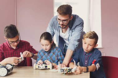 Eğitim kaynaklanıyor. Çocuklar robotlar öğretmen ile oluşturma