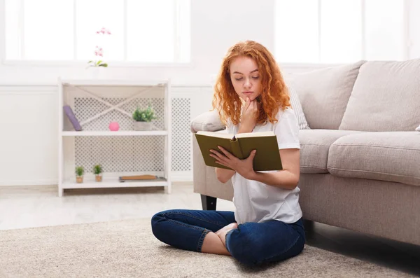 Chica reflexiva leyendo en casa — Foto de Stock