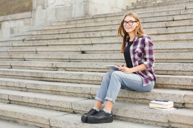 Mutlu genç kadın dijital tablet açık havada kullanma