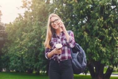 Öğrenci kız mobil kahve fincanı ile konuşmak