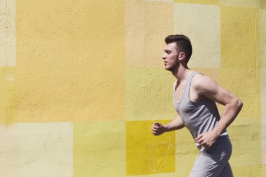 Parlak duvara koşan adam yan görünüm