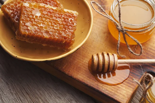 Golden honeycombs and honey jar, closeup — Stock Photo, Image