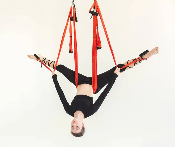 Woman practicing fly yoga over white background