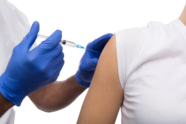 Black male hand in blue gloves holding a plastic syringe — Stock Photo, Image