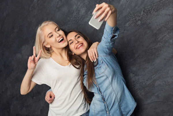 Dwie kobiety szczęśliwy biorąc selfie w studio tło — Zdjęcie stockowe