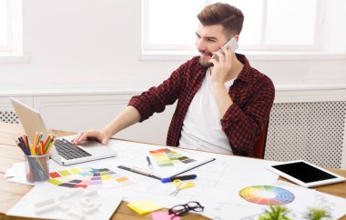 Konsantre genç tasarımcı vardır mobil telefon konuşma