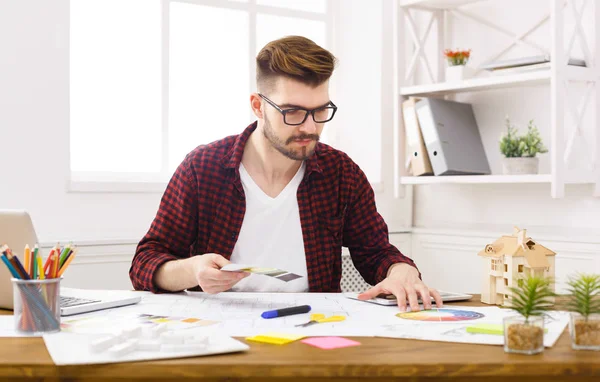 Joven diseñador trabajando con planos en la oficina — Foto de Stock