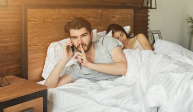 Sakallı adam yatakta smartphon sabah konuşurken