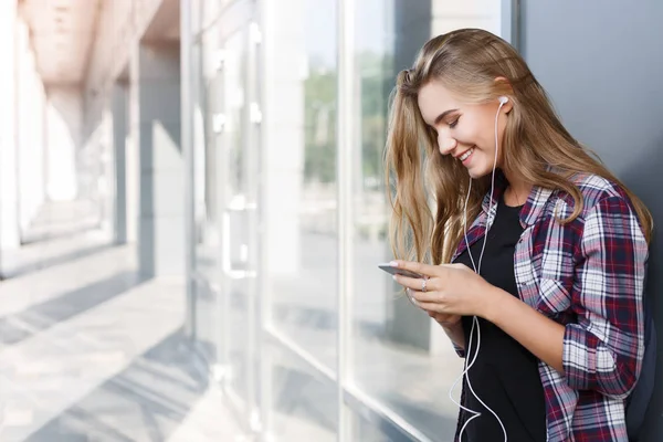 Boldog fiatal nő használ smartphone szabadban — Stock Fotó