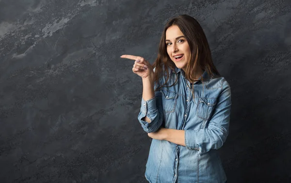 Jovem mulher feliz apontar para longe — Fotografia de Stock