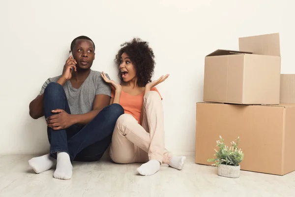 Black couple sitting on floor at new apartment