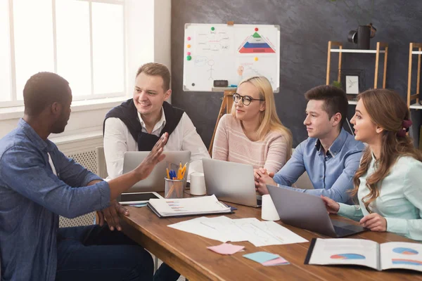 Junges Team diskutiert Projekt in modernem Büro — Stockfoto