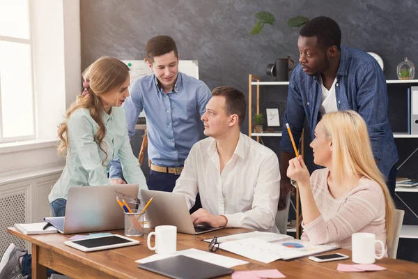 Företagets medarbetare diskuterar idéer i office — Stockfoto