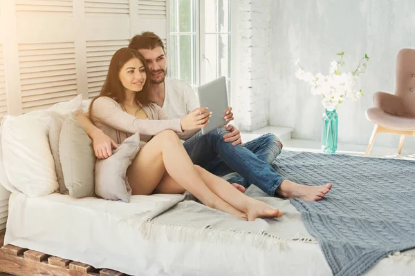 Mutlu çift yatak odalı evde tablet ile — Stok fotoğraf
