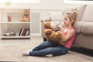 Küçük kız onun oyuncak ayı katta sarılma