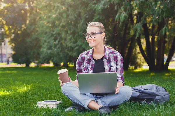 Mujer joven feliz usando el ordenador portátil en el parque — Foto de Stock