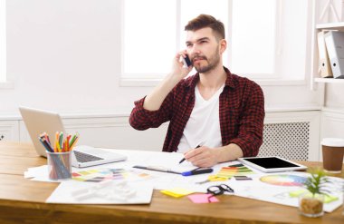 Konsantre genç tasarımcı vardır mobil telefon konuşma